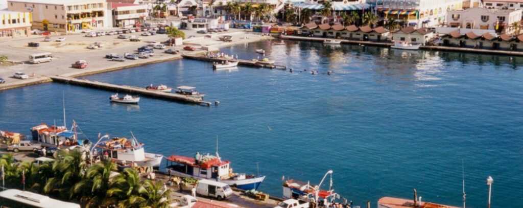 Aerial view of Oranjestad's inner harbor with colorful buildings and fishing boats